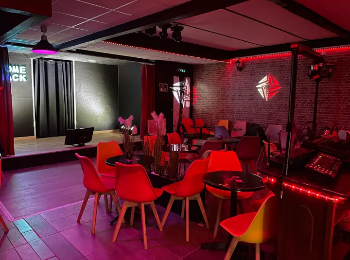 La salle du COME-BACK, avec ses tables et sa scène